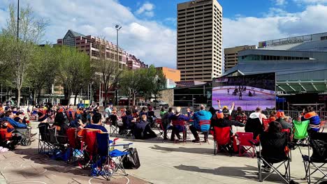 Sunny-cold-fan-party-watching-Oilers-vs-Knights-during-Stanley-Cup-playoffs-in-Vegas-as-cold-fans-watch-anticipating-a-win-to-an-exciting-goal-cheering-with-family-and-friends-outside-at-big-screen-tv