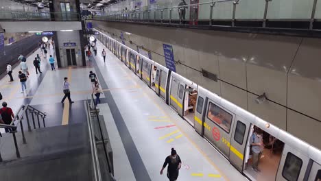 passenger-walking-at-metro-station-with-metro-train-standing-at-morning-from-top-angle-video-is-taken-at-hauz-khas-metro-station-new-delhi-india-on-Apr-10-2022