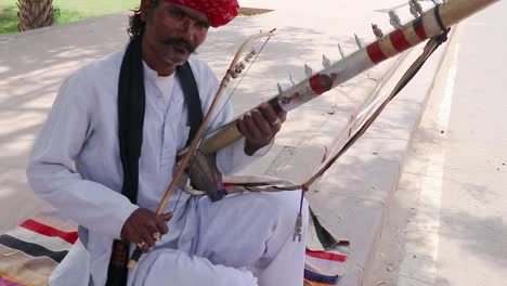 man-playing-traditional-musical-instrument-in-authentic-local-dress-at-street-of-india-at-morning-video-is-taken-jodhpur-rajasthan-india-on-Apr-11-2023
