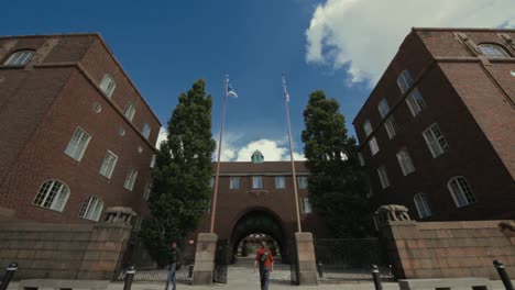 Low-angle-view-of-the-arched-entrance-to-KTH-University-as-students-enter-and-exit-the-campus