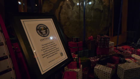Guiness-World-Record-certificate-displayed-next-to-wrapped-presents-in-front-of-a-large-pendulum-behind-glass