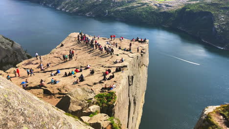 Crowd-of-enthusiastic-tourists-enjoying-on-the-cliff-edge-of-Preikestolen-Pulpit-Rock-in-Rogaland-county,-Norway