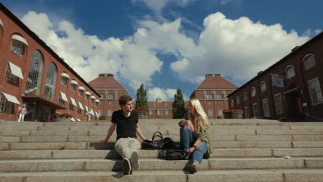 KTH-students-sit-on-steps-near-two-brick-buildings-on-the-Stockholm-campus