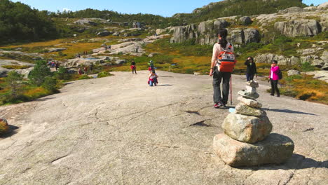 Excited-active-lady-tourist-posing-for-a-photograph,-on-the-Preikestolen-Pulpit-Rock-in-Rogaland-county,-Norway