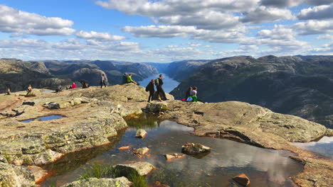 Tourist-hikers-relaxing-on-the-calm-top-edge-of-Preikestolen-Pulpit-Rock-in-Rogaland-county,-Norway