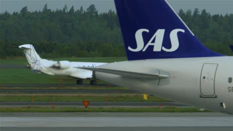 Passenger-airline-passing-by-another-parked-aircraft-at-the-Stockholm-Airport-in-Sweden