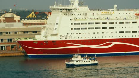 Toma-Aérea-De-Un-Gran-Crucero-Amarrado-En-El-Puerto-De-Helsinki-Y-Pequeños-Barcos-Navegando-Cerca