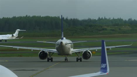 Aviones-De-Pasajeros-Que-Se-Mueven-En-La-Pista-Del-Aeropuerto-De-Estocolmo-En-Suecia-En-Un-Día-Nublado
