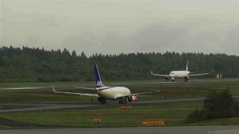 An-airplane-taking-off-while-another-airplane-taxiing-towards-the-runway-at-Stockholm-Arlanda
