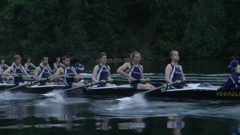 College-athletes-row-on-a-calm-lake-as-the-camera-pushes-in-cinematically