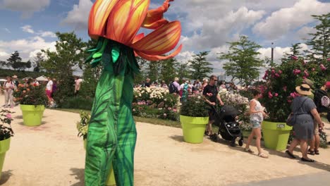 Flower-mascot-entertainers-walking-around-at-State-Garden-Show-Heilbronn,-Germany-panning-shot