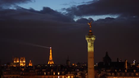 Blick-Auf-Den-Place-De-La-Bastille-Mit-Dem-Eiffelturm-Im-Hintergrund,-Abends-Beleuchtet