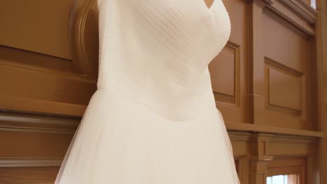 Tilt-down-display-of-wedding-dress-in-front-of-a-window