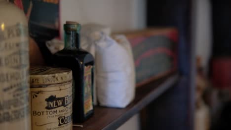 Various-old-fashioned-expired-goods-products-displayed-on-wooden-museum-shelf-with-branding