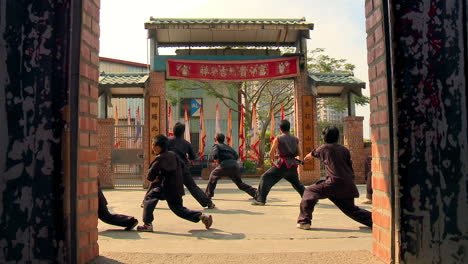 Batch-of-chinese-kids-learning-martial-arts-under-supervision-at-dojo