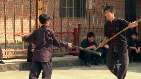 Learner-martial-arts-student-practicing-to-stick-fight-from-sensei