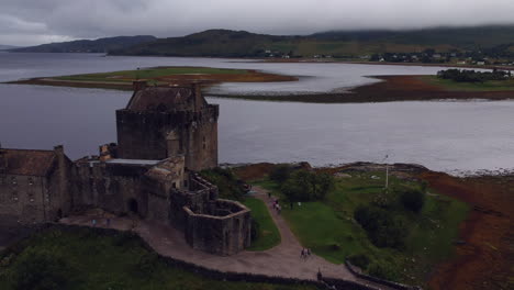 Eilean-Donan-Castle-drone-shot-at-sunset-on-cloudy-moody-day