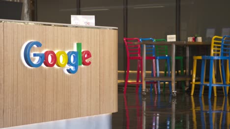 Google-front-desk-with-logo-and-company-coloured-chairs-in-background