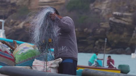 Fischer-Sammelt-Ein-Fischernetz-In-Einem-Boot-In-Ecuador