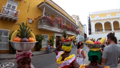 Palenqueras-In-Cartagena-Tragen-Farbenfrohe-Kleider-Und-Balancieren-Obstschalen-Auf-Ihren-Köpfen
