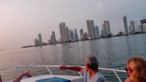 Los-Turistas-Señalan-A-Los-Delfines-Que-Nadan-En-El-Océano-De-Cartagena-De-Indias,-Colombia.
