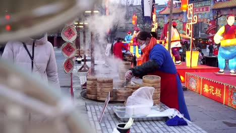 Eine-Frau-Bereitet-Traditionelles-Essen-In-Der-Wasserstadt-Gubei,-Peking,-Auf-Der-China-Messe-Zu,-Während-Die-Menschen-Auf-Das-Chinesische-Neujahrsfest-Warten