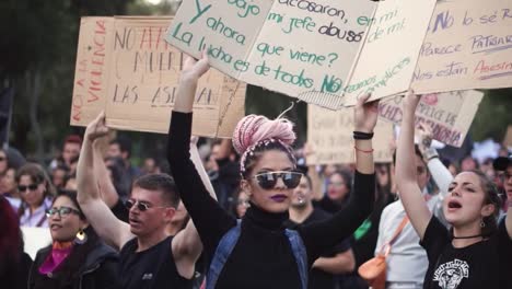 Women-and-men-peacefully-protesting,-marching-and-chanting-songs-against-inequality,-marches-in-favor-of-women-rights-with-messages-written-on-boards