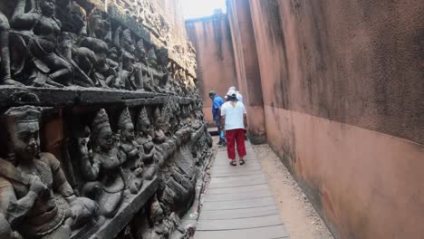 Touristen-Bleiben-Stehen-Und-Bewundern-Die-Steinernen-Buddhas,-Die-Die-Gänge-Zur-Terrasse-Der-Elefanten-Schmücken