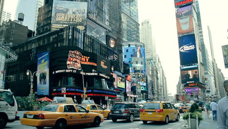 Yellow-taxis-and-people-walking-in-a-crowded-time-square-during-the-morning