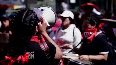 A-woman-in-Quito,-Ecuador-is-using-a-megaphone-at-a-rally-in-a-protest-in-favor-of-women's-rights-and-gender-violence