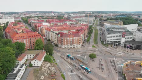 Aerial-video-of-Korsvagen-in-the-central-part-of-Gothenburg,-Sweden,-with-beautiful-apartment-buildings-and-some-nice-green-trees-and-bushes-around-them,-Ullevi-in-the-background