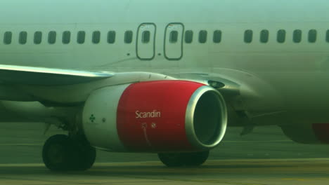 Aircraft-of-Scandinavian-airline-being-pulled-by-airport-tractor