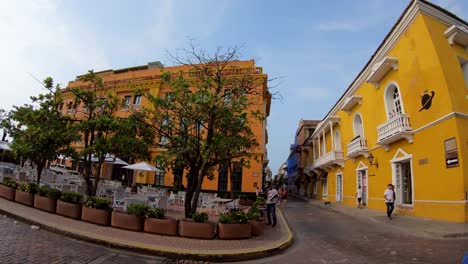 Several-people-are-walking-on-the-sidewalks-and-street-of-the-old-town-of-Cartagena-de-Indias,-Colombia