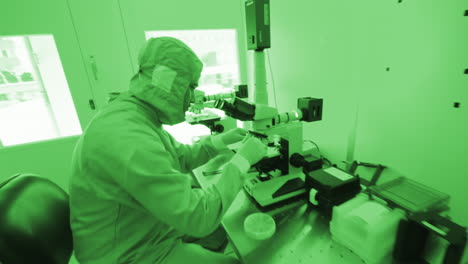 Laboratory-worker-using-a-microscope-in-a-scientific-lab,-Dolly-Close-Up