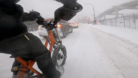 Side-Angle-POV-Of-Courier-On-Radburro-Slowing-Down-To-Stop-Before-Red-Light-In-Heavy-Snow-In-Montreal