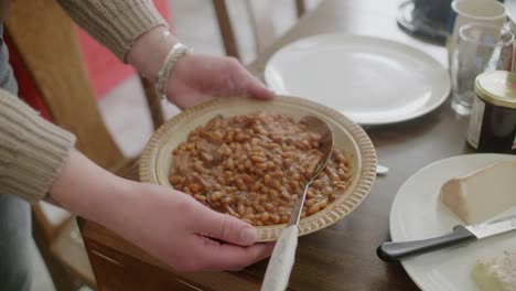 Plate-Full-Of-Hot-Baked-Beans-Being-Placed-On-Table