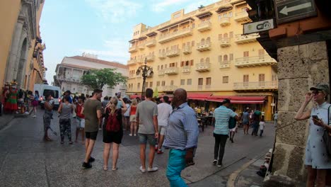 A-lot-of-tourists-are-walking-and-standing-on-a-plaza-of-the-old-town-of-Cartagena-de-Indias,-Colombia