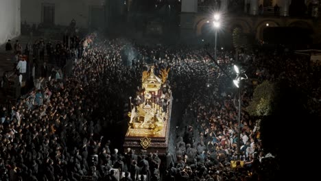 People-Dressed-In-Black-Carrying-Giant-Float-During-Holy-Week-Procession-In-Antigua,-Guatemala---drone-static