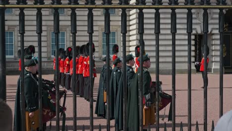 Watching-Changing-Of-The-Guards-Ceremony-Through-Iron-Fence-Of-The-Buckingham-Palace-In-London,-UK