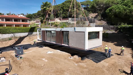 Construction-site-of-modular-home-with-lifted-module,-aerial-dolly-forward-view