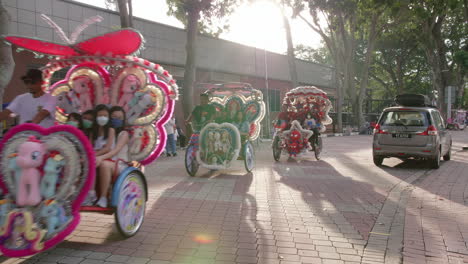 Tourists-enjoying-ride-of-beautiful-vibrant-decorated-trishaws,Malacca