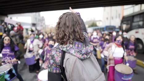 Eine-Frau-Führt-Eine-Gruppe-Violett-Gekleideter-Frauen-An,-Die-Während-Des-Protestmarsches-Zum-Internationalen-Frauentag-In-Quito,-Ecuador,-Schlagzeug-Spielen