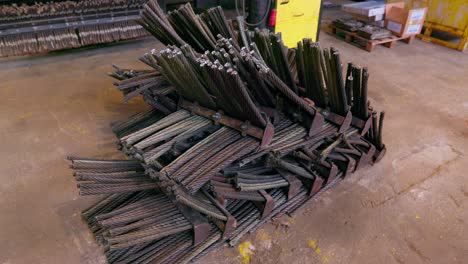 Pile-of-spiral-metal-steel-rods,-wide-shot-in-a-factory