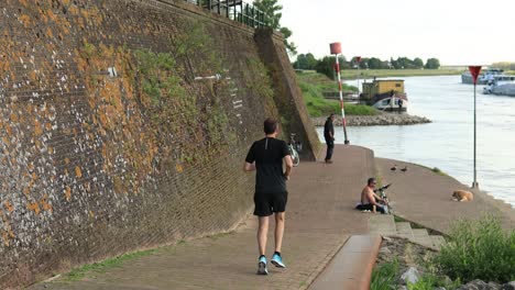 Sportler-Ausdauertraining,-Lauftraining-Im-Freien,-Sport-Workout-Konzept-Am-Flussufer-Entlang-Der-Historischen-Stadtverteidigungsmauer