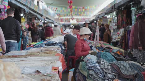 Vendedores-Locales-Y-Puestos-Tradicionales-Venden-Textiles-Y-Ropa-En-El-Concurrido-Y-Colorido-Mercado-De-Estafas-En-Danang,-Vietnam