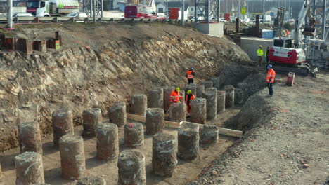 Construction-workers-checking-circular-concrete-blocks-in-roadside-dig
