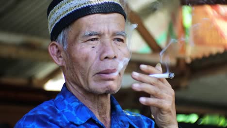 Malay-old-man-smoking-casually-in-the-morning-in-front-of-his-garden