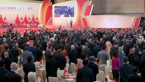 Government-officials-and-Pro-China-guests-are-seen-at-the-ceremony-celebrating-China's-National-Day-on-October-1st-as-Hong-Kong-and-Chinese-flags-hang-from-the-wall-in-the-background