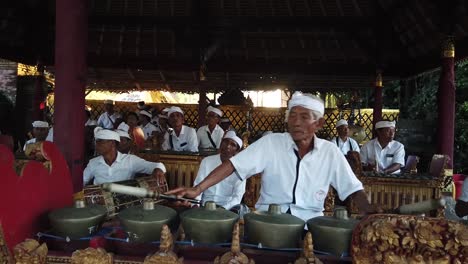 Elder-Man-Plays-Ancient-Musical-Gamelan-Music-in-Spiritual-Ceremony-at-Bali-Indonesia,-Hand-Held-Shot