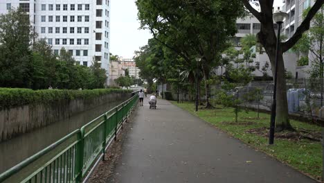 View-of-an-elderly-using-electric-PMA-scooters-to-move-around-comfortably-and-safely-at-Whampoa-Park-Connector,-Singapore